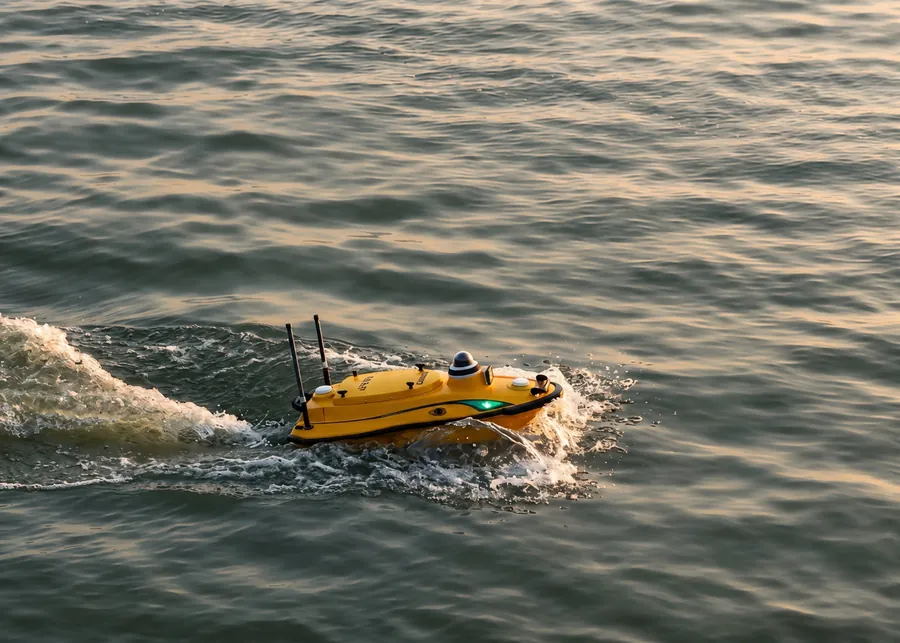 Embarcación no tripulada de sondaje navegando en aguas abiertas, dejando su estela.