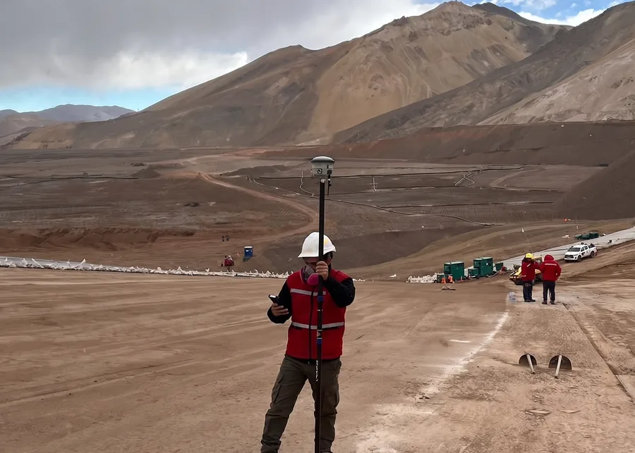 Operador con jalón GNSS sobre una plataforma nivelada en alta montaña.
